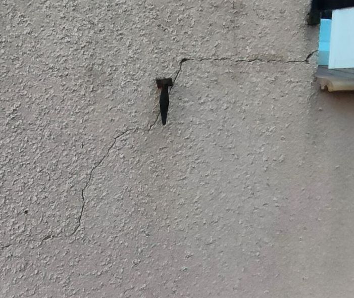 Avant réparation d'une fissure dans un mur à côté d'un volet