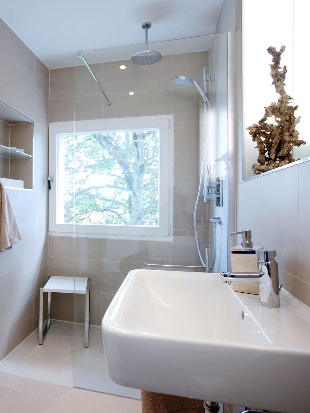 Ein Badezimmer mit Waschbecken und ebenerdiger Dusche