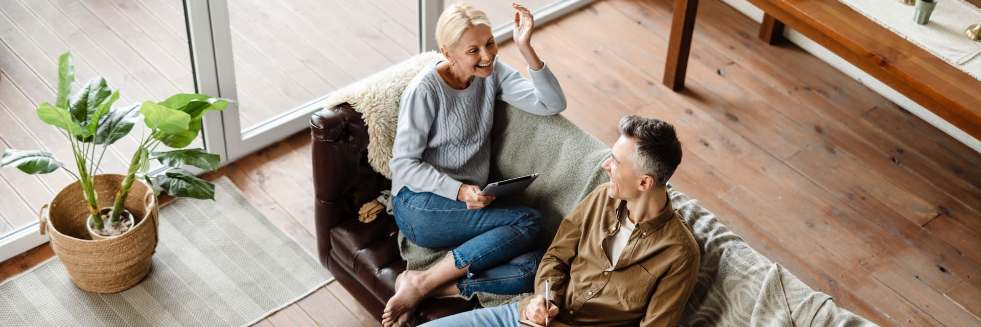 Ein Mann und eine Frau sitzen auf einem Sofa und unterhalten sich.