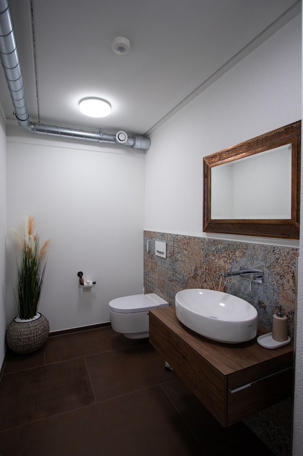 Ein Badezimmer mit Toilette, Waschbecken und Spiegel.