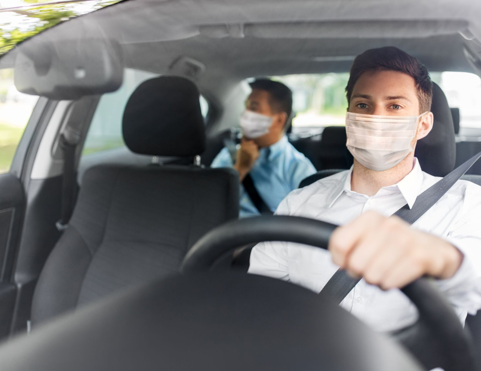 Homme dans un véhicule portant un masque