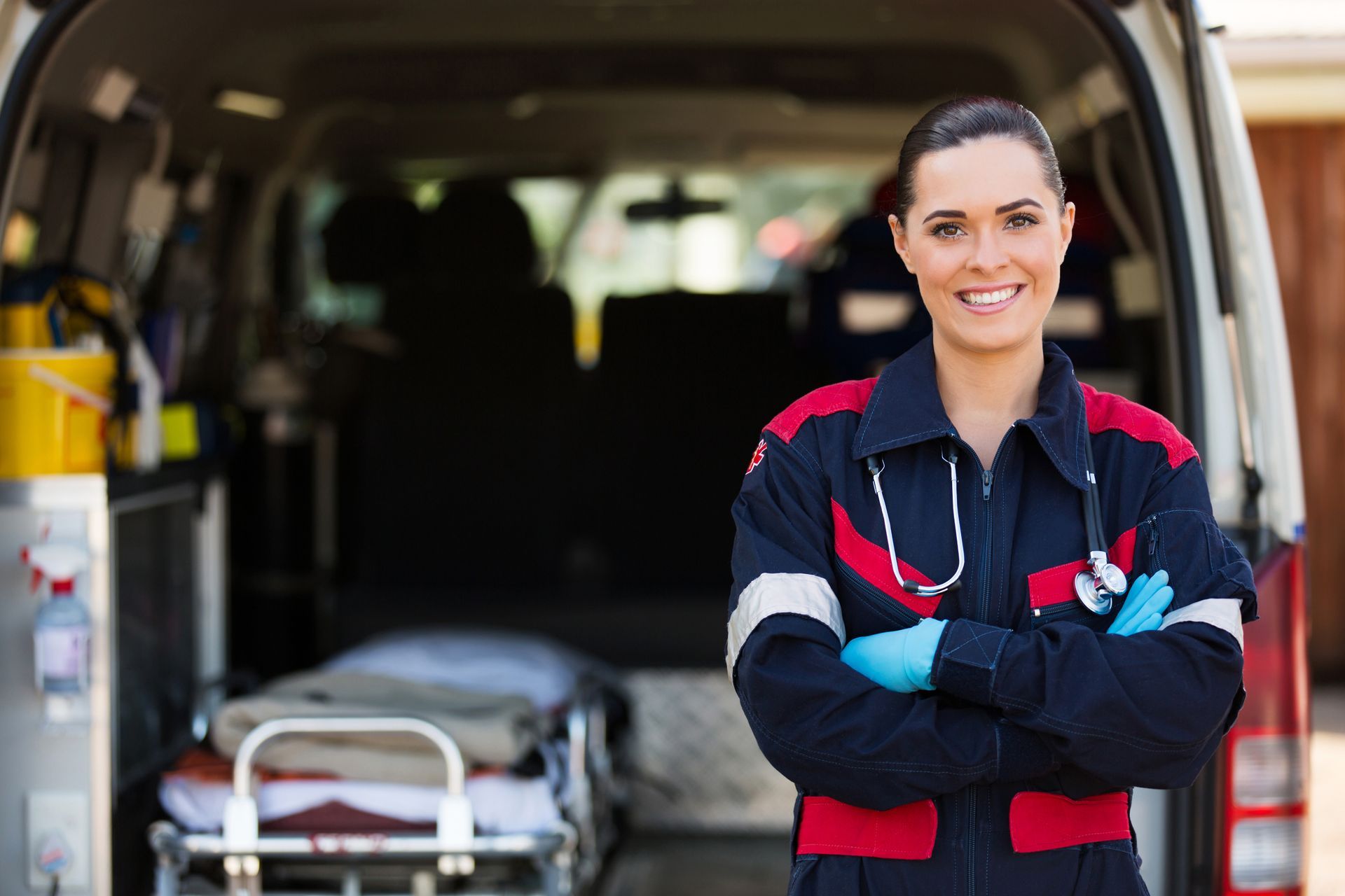 Femme ambulancier sourit devant une ambulance