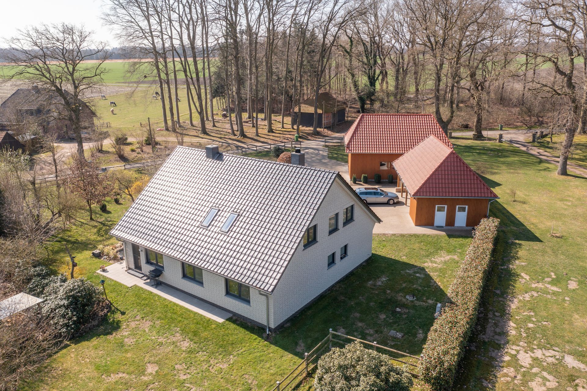 Eine Luftaufnahme eines Hauses und einer Scheune auf einem Feld.