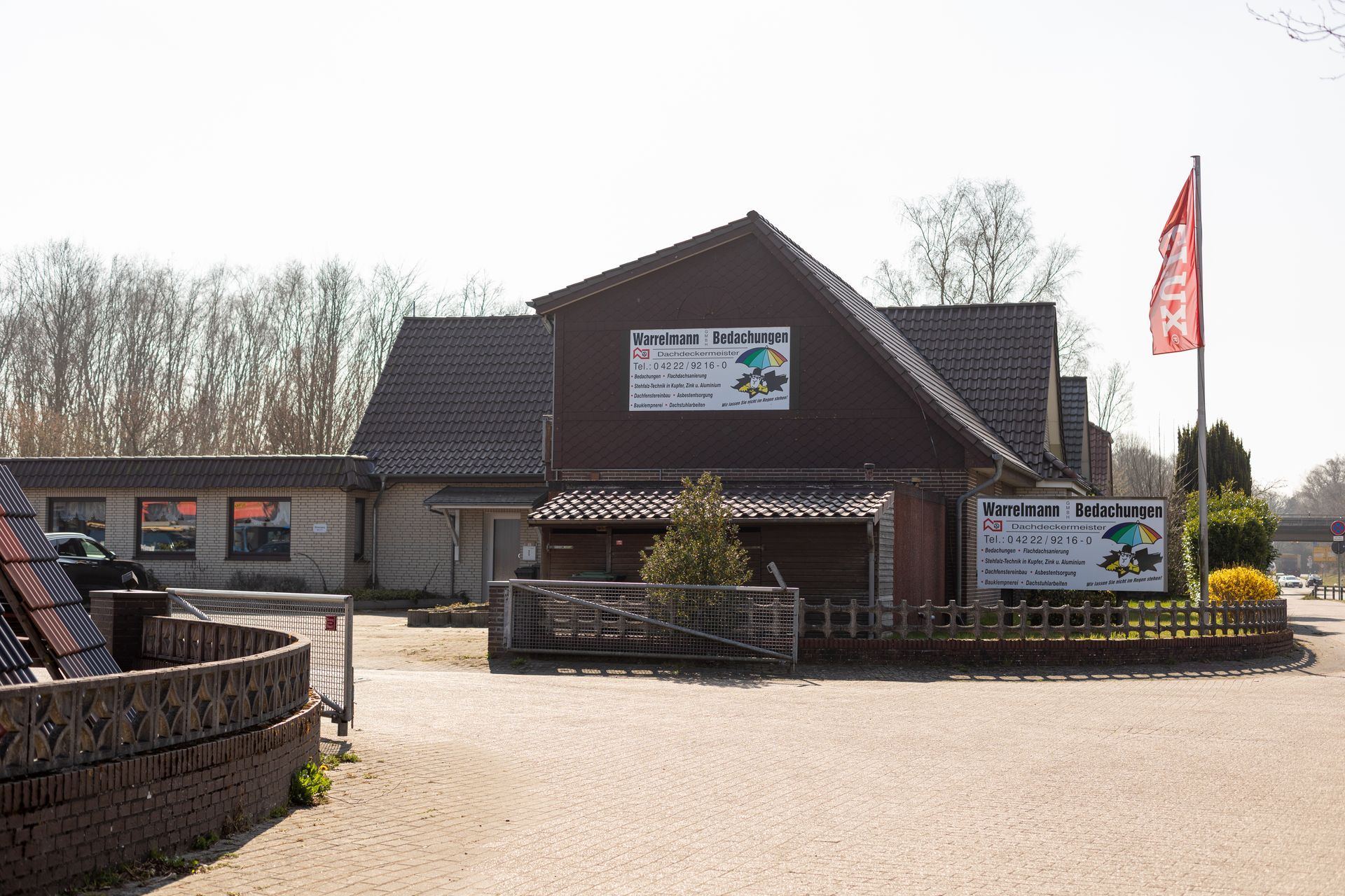 Ein großes braunes Gebäude, vor dem eine rote Flagge weht.