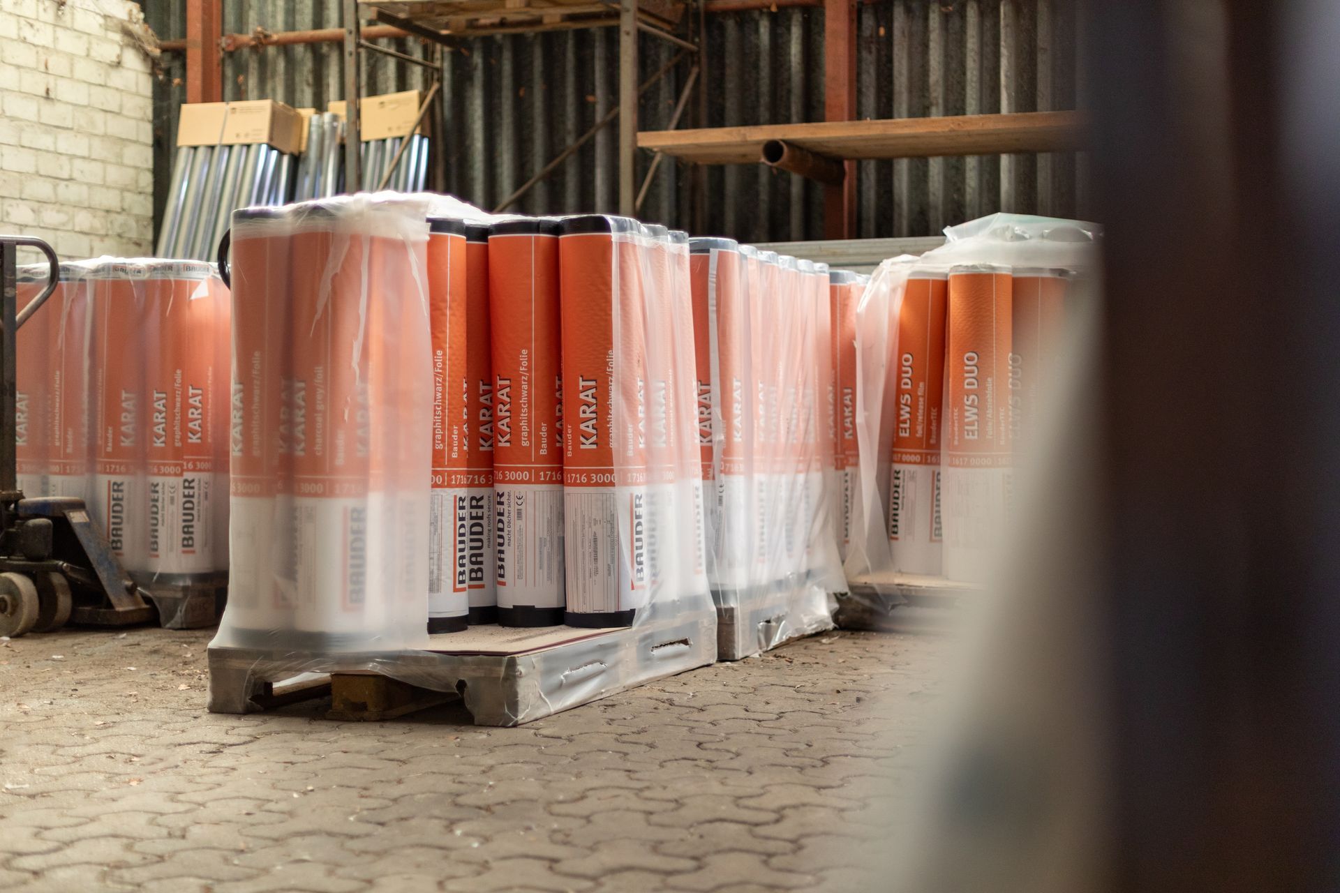 Ein Lagerhaus voller Rollen aus in Plastik eingewickeltem Dachmaterial.