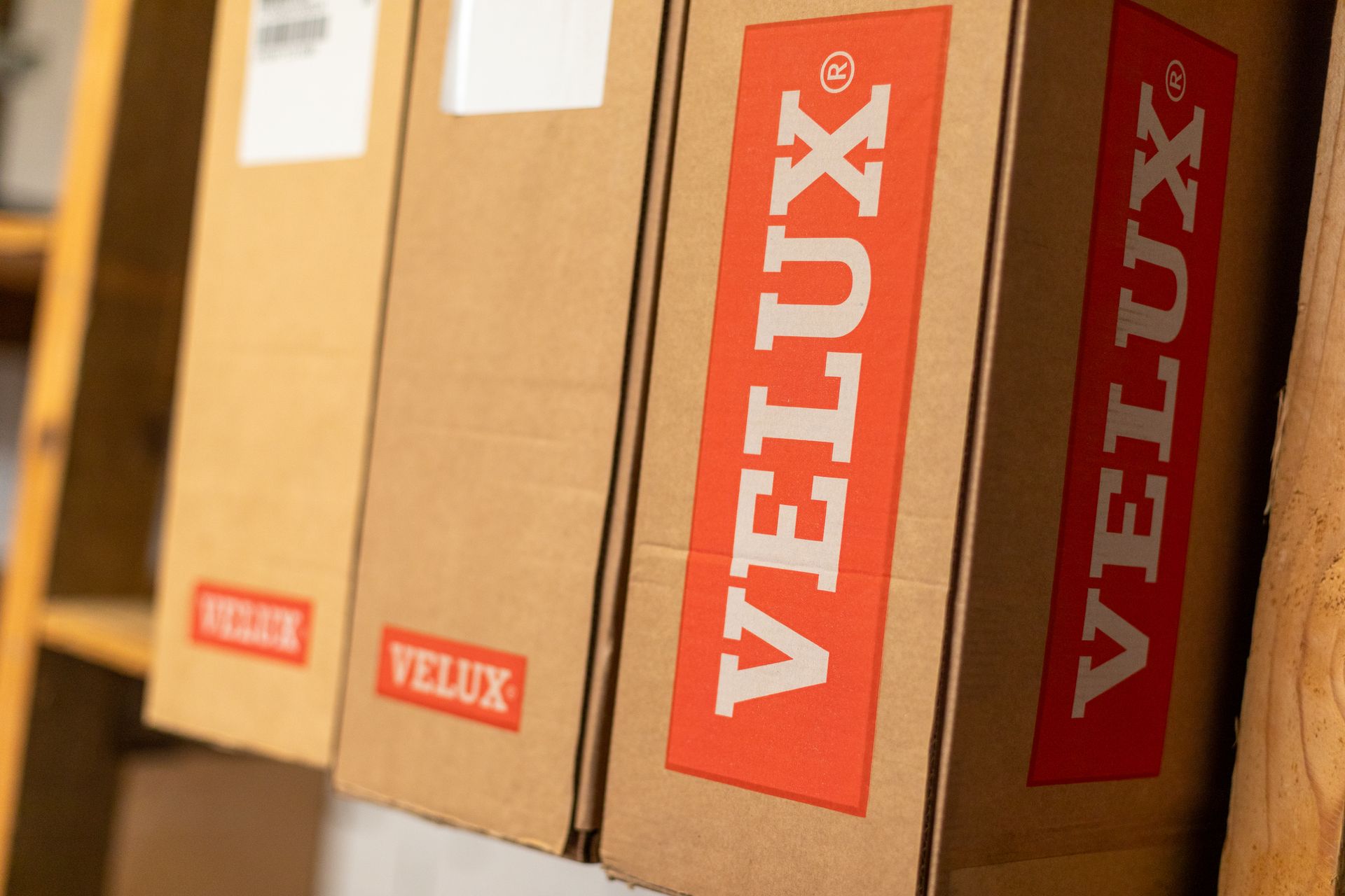 Eine Reihe von Velux-Kästen auf einem Holzregal.