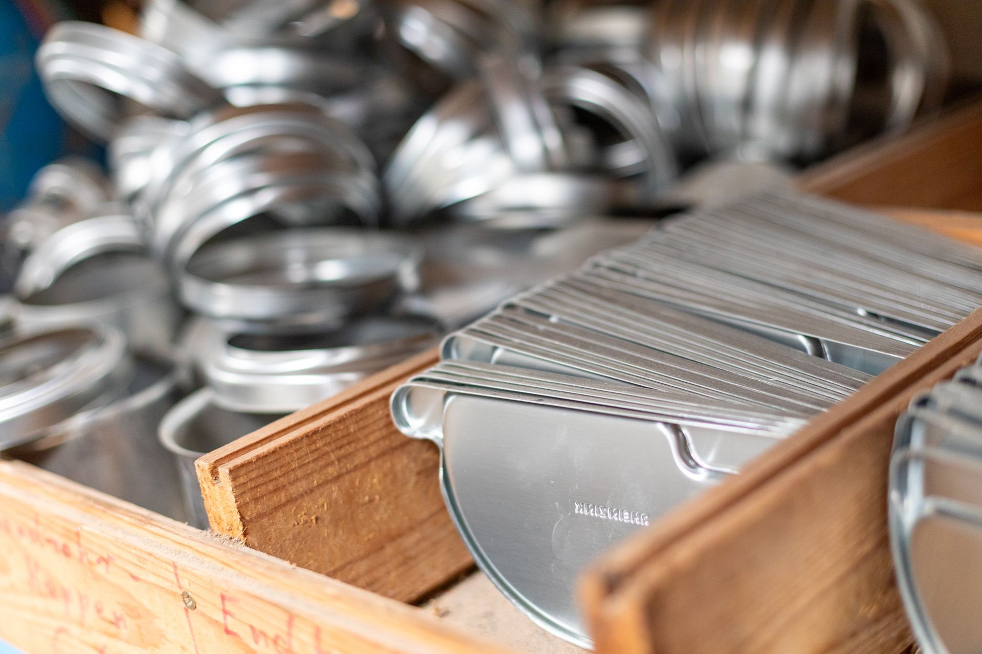 Eine Holzkiste, die mit verschiedenen Metallgegenständen gefüllt ist.