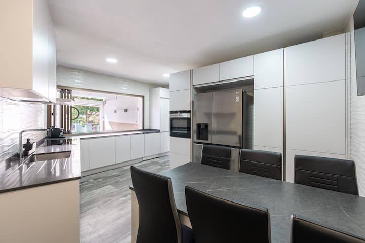 Una cocina con mesa y sillas y un frigorífico.