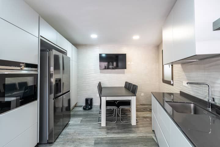 Una cocina con mesa y sillas y un frigorífico.