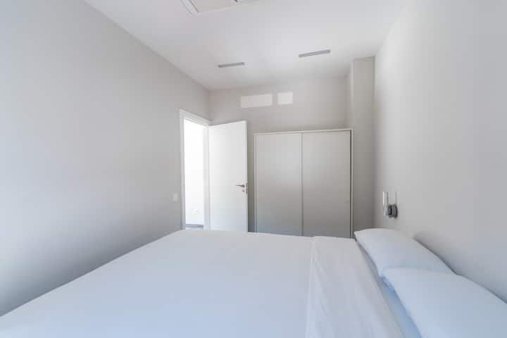 Un dormitorio con cama, armario y puerta.