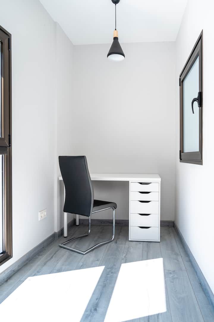 Una pequeña habitación con un escritorio y una silla.