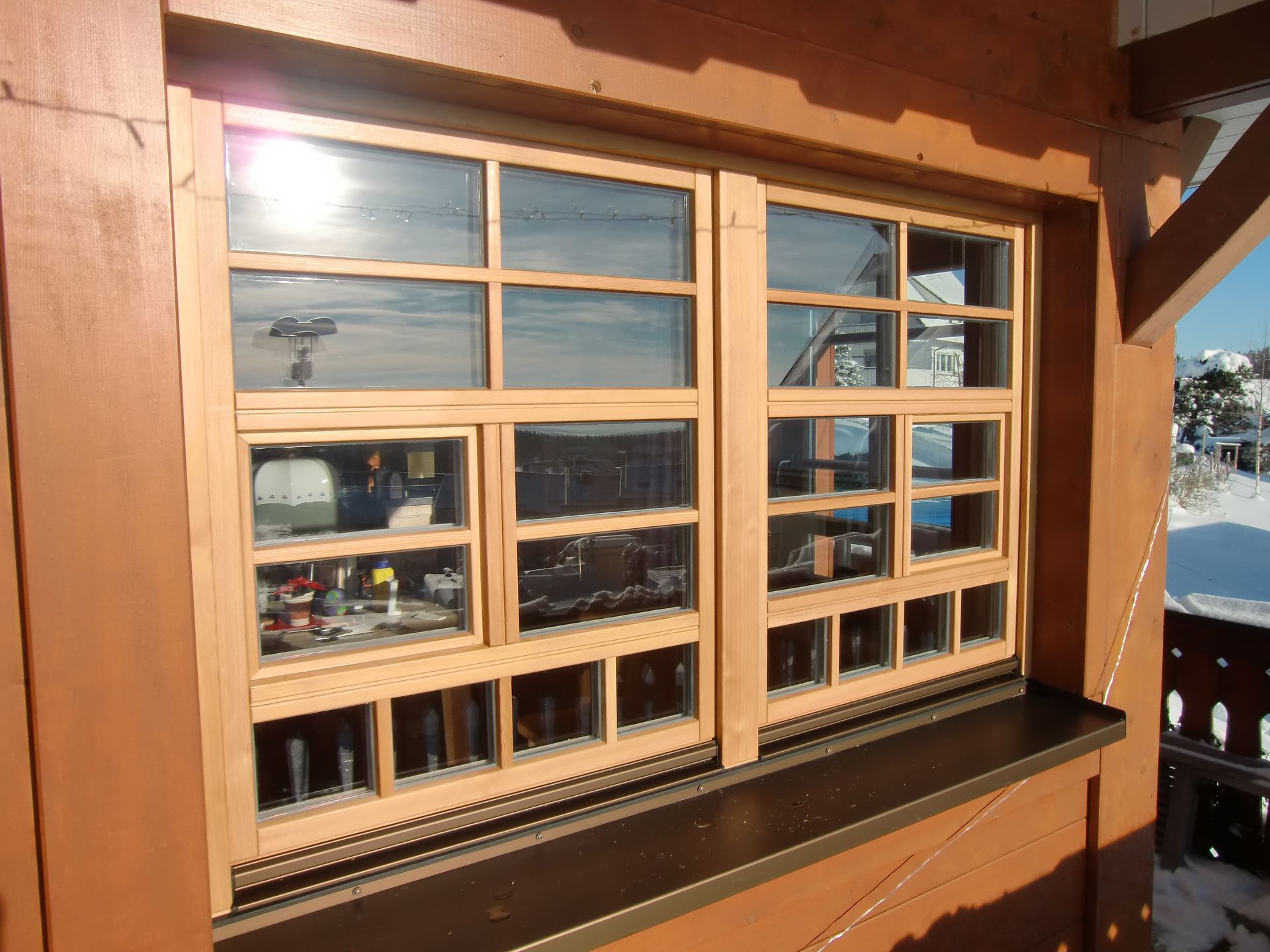 Die Sonne scheint durch die Holzfenster eines Gebäudes. Foto von der Schreinerei Thomas Sigwart