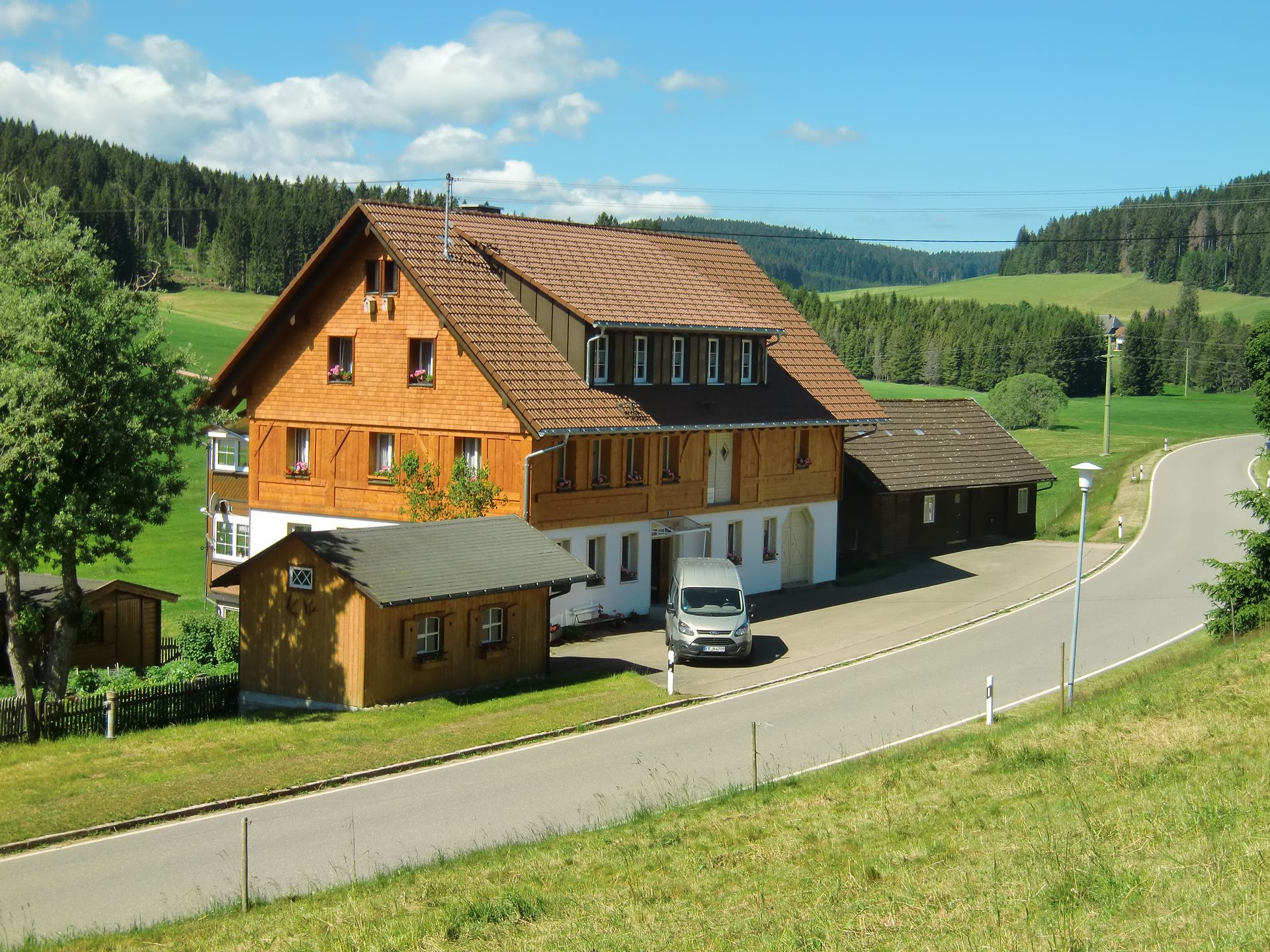 Ein weißer Lieferwagen steht vor einem großen Haus. Foto von der Schreinerei Thomas Sigwart