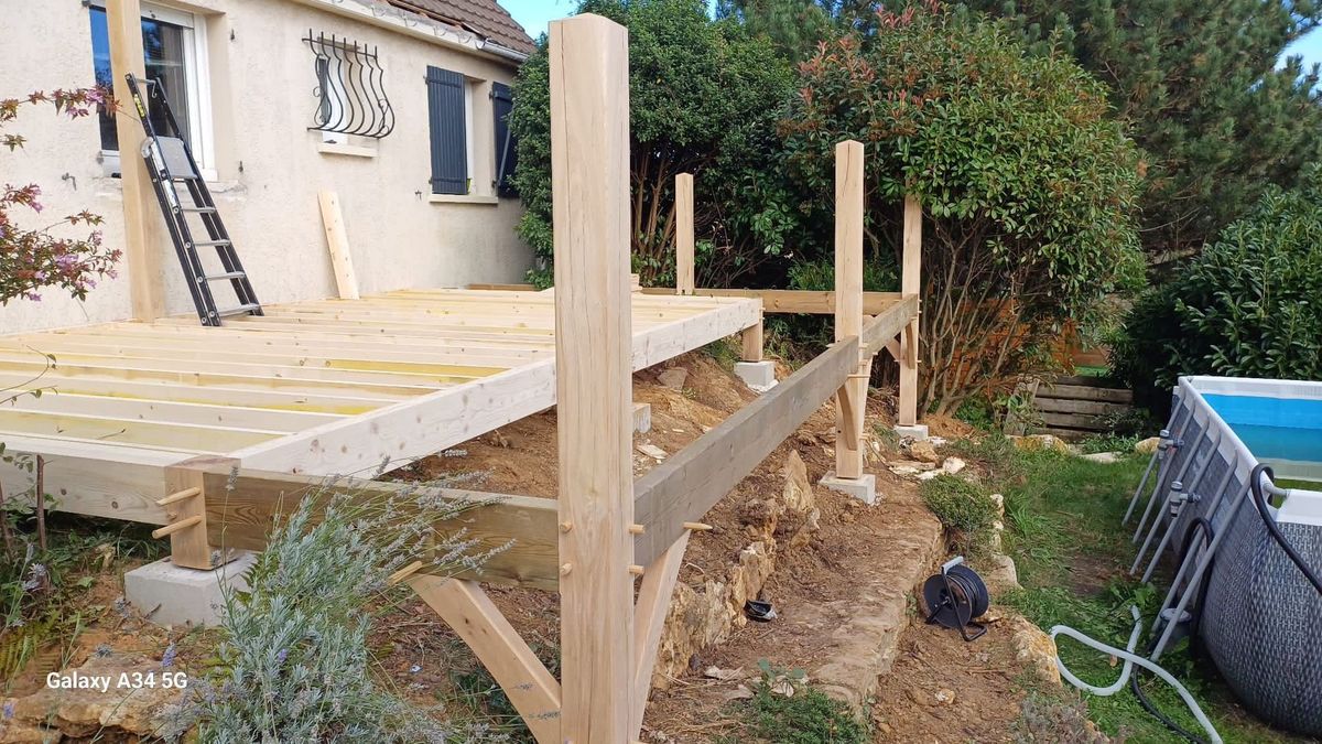 Construction d'une terrasse en bois clair surélevée sur le côté d'une maison