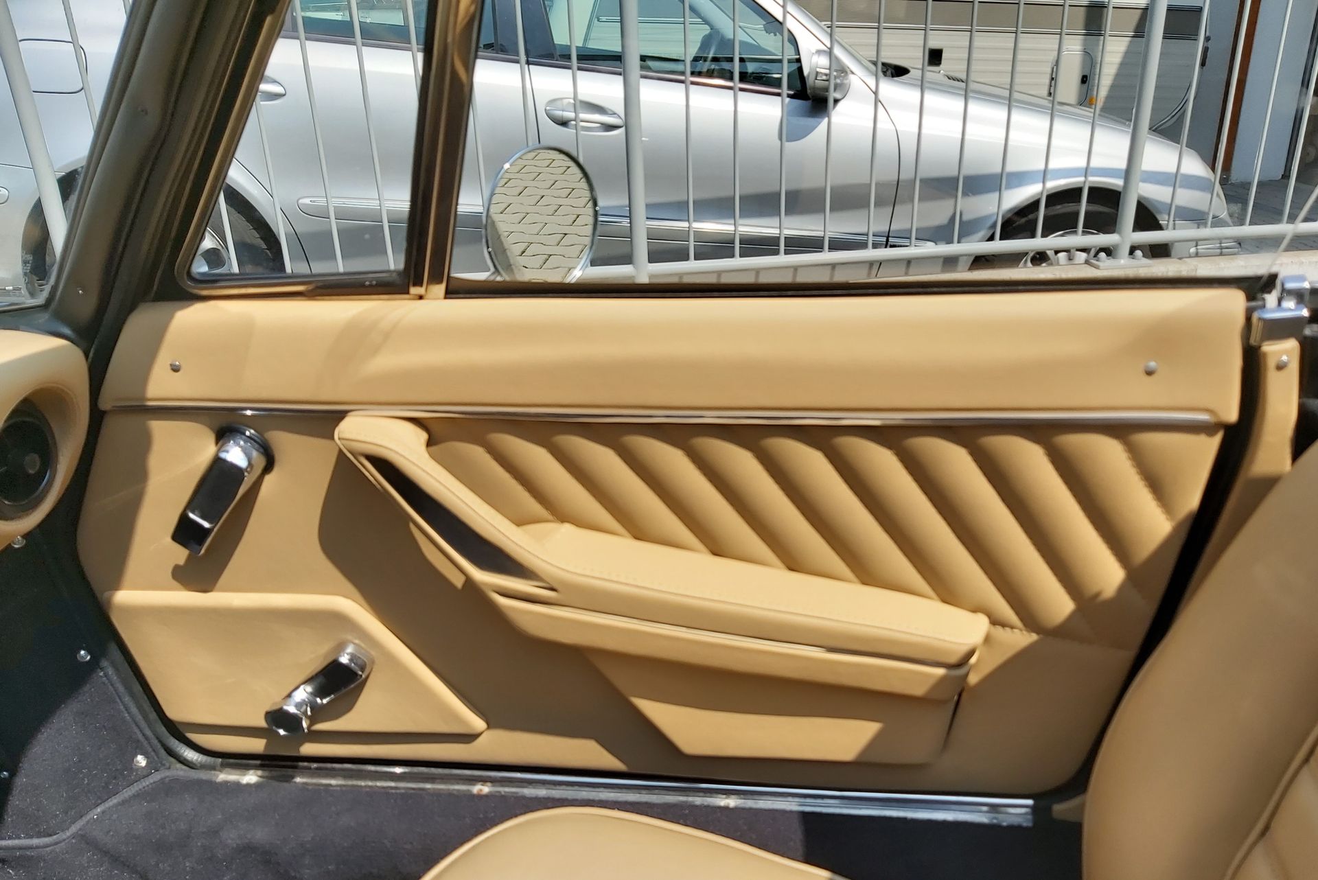 Eine Autotür mit einem silbernen Auto im Hintergrund