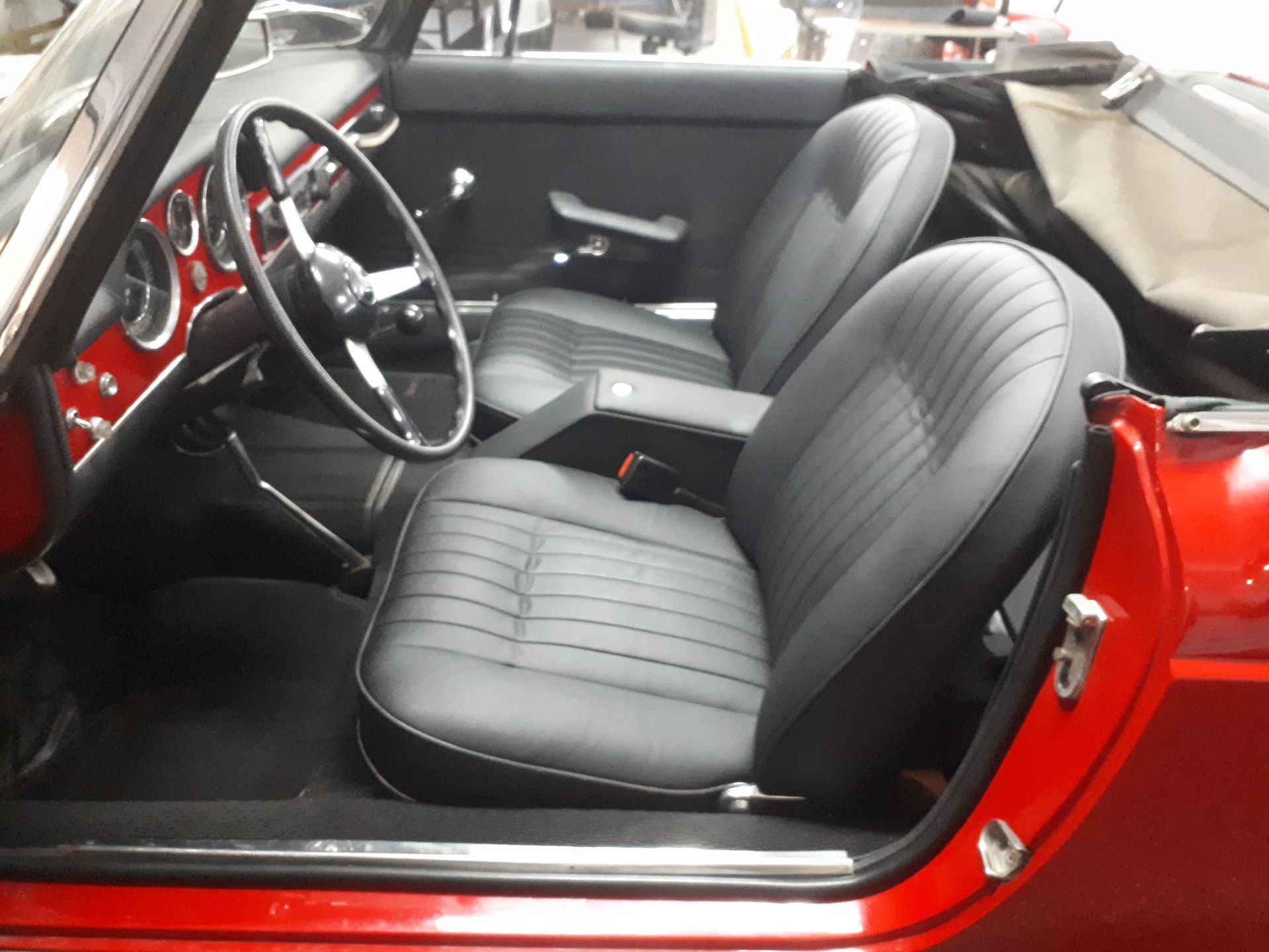 Ein rotes Auto mit schwarzen Sitzen und einem Lenkrad