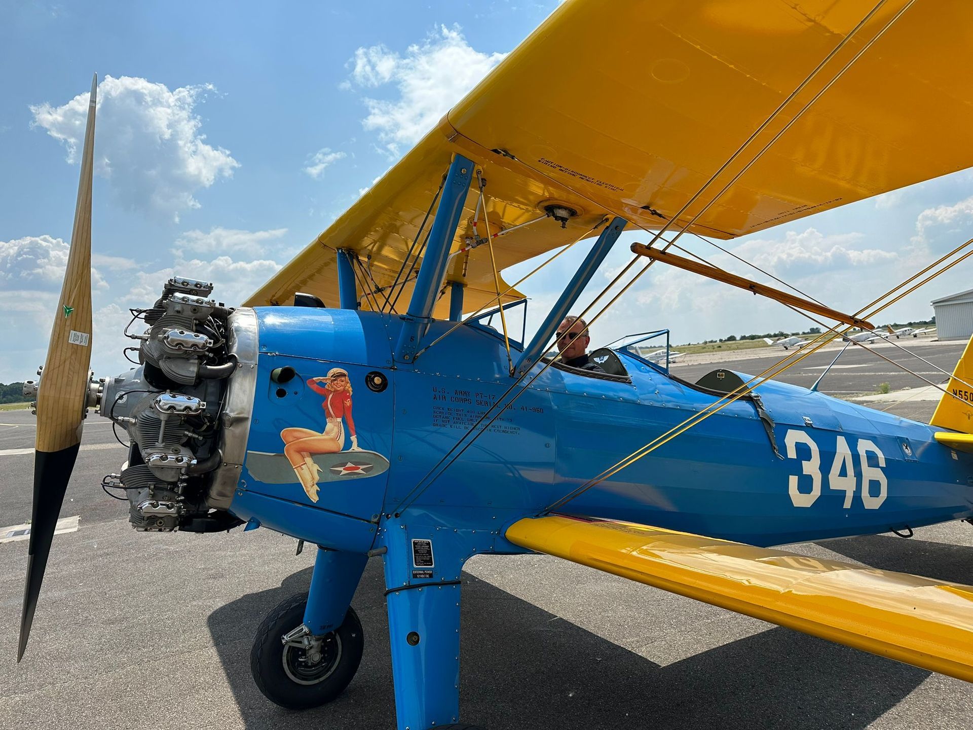 Auf dem Boden steht ein blau-gelbes Flugzeug mit der Nummer 348 an der Seite.