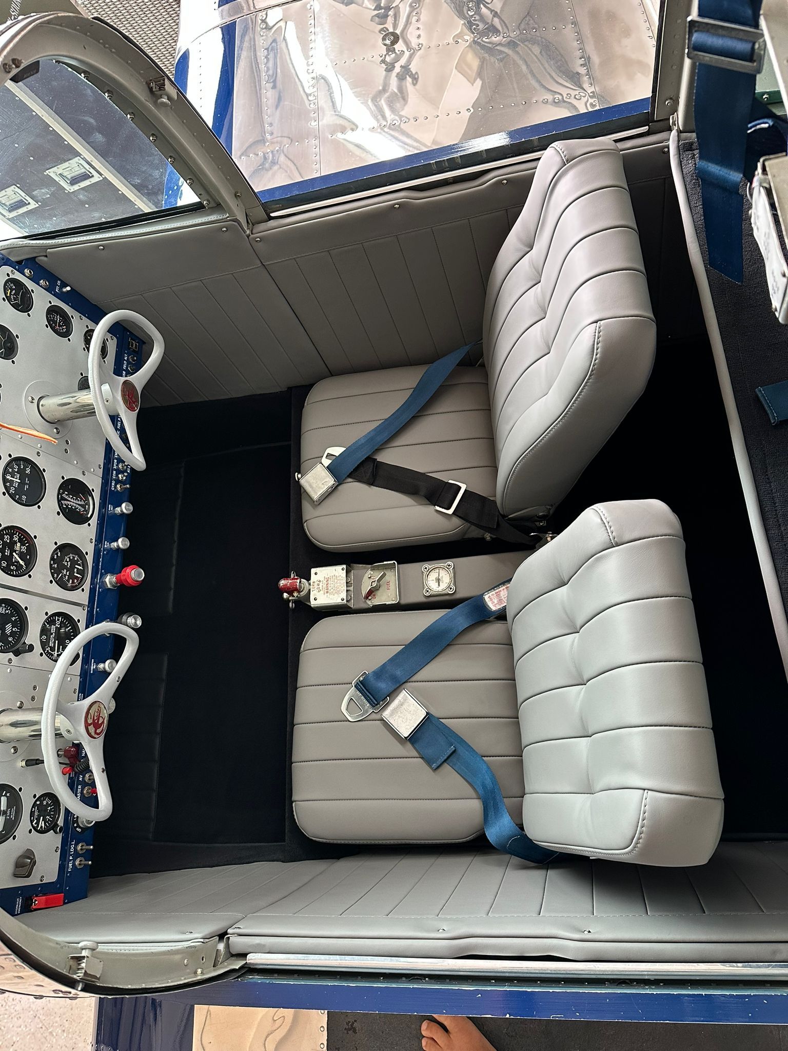 Das Innere eines Flugzeugs mit Sitzen und einem blauen Sicherheitsgurt.