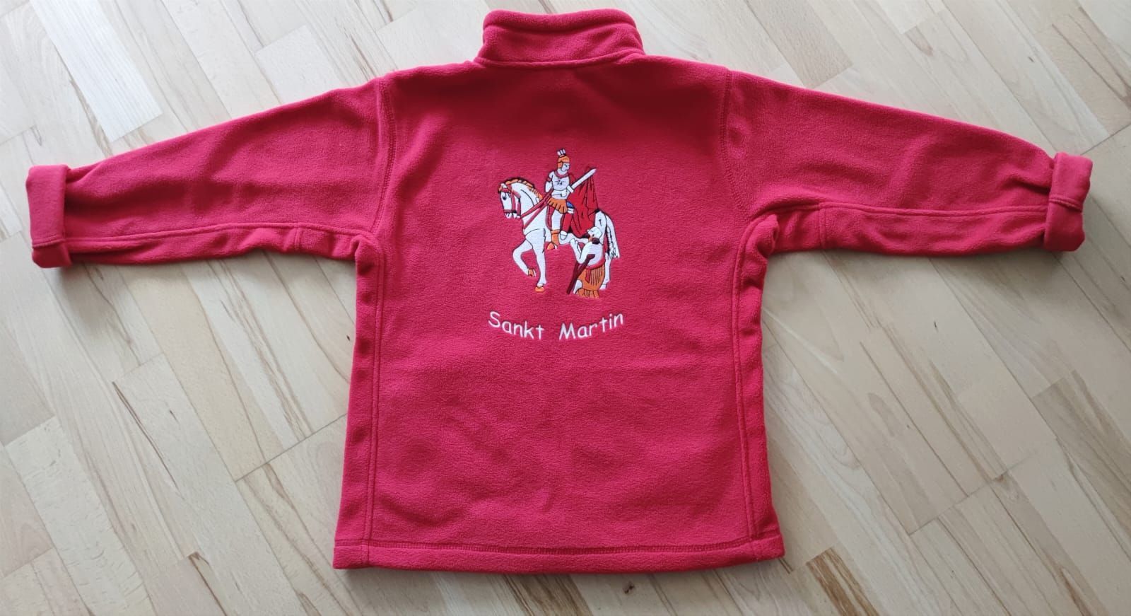 Ein roter Pullover mit einem Ritter auf einem Pferd auf dem Rücken