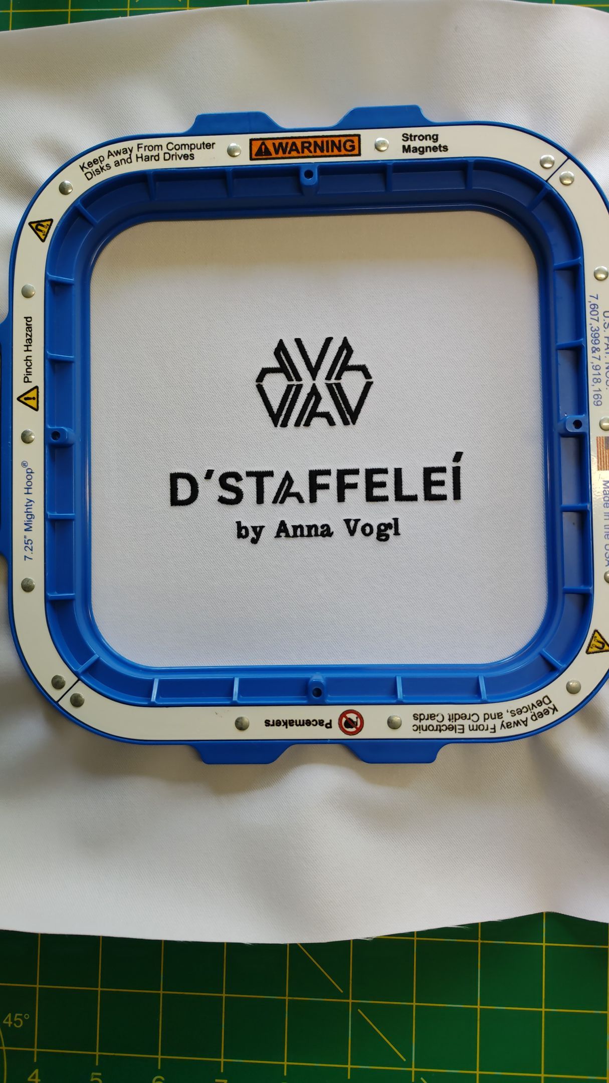 Ein blauer Stickrahmen mit dem Wort d'Staffelei darauf