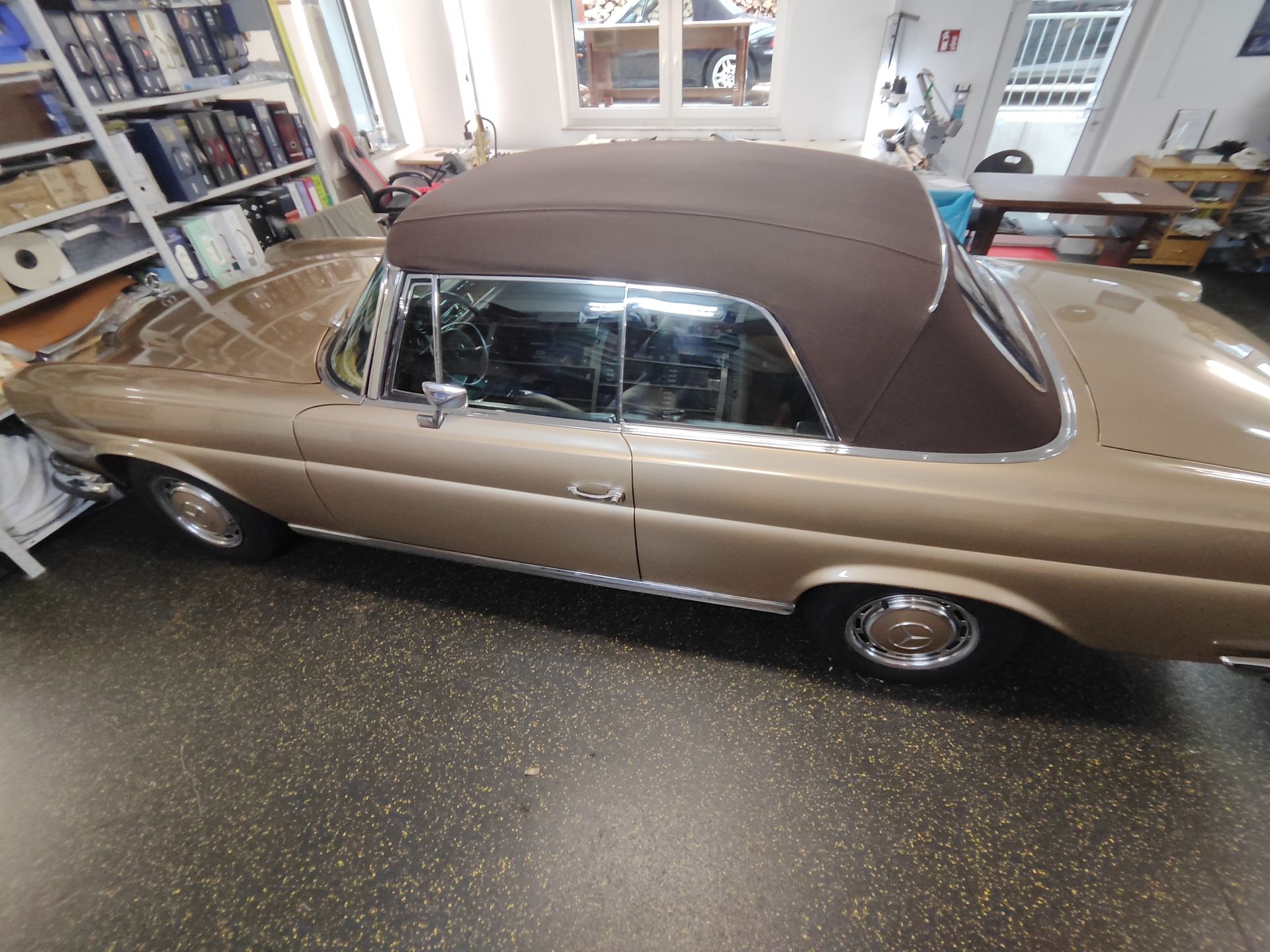 Ein Auto mit braunem Dach steht in einer Garage.