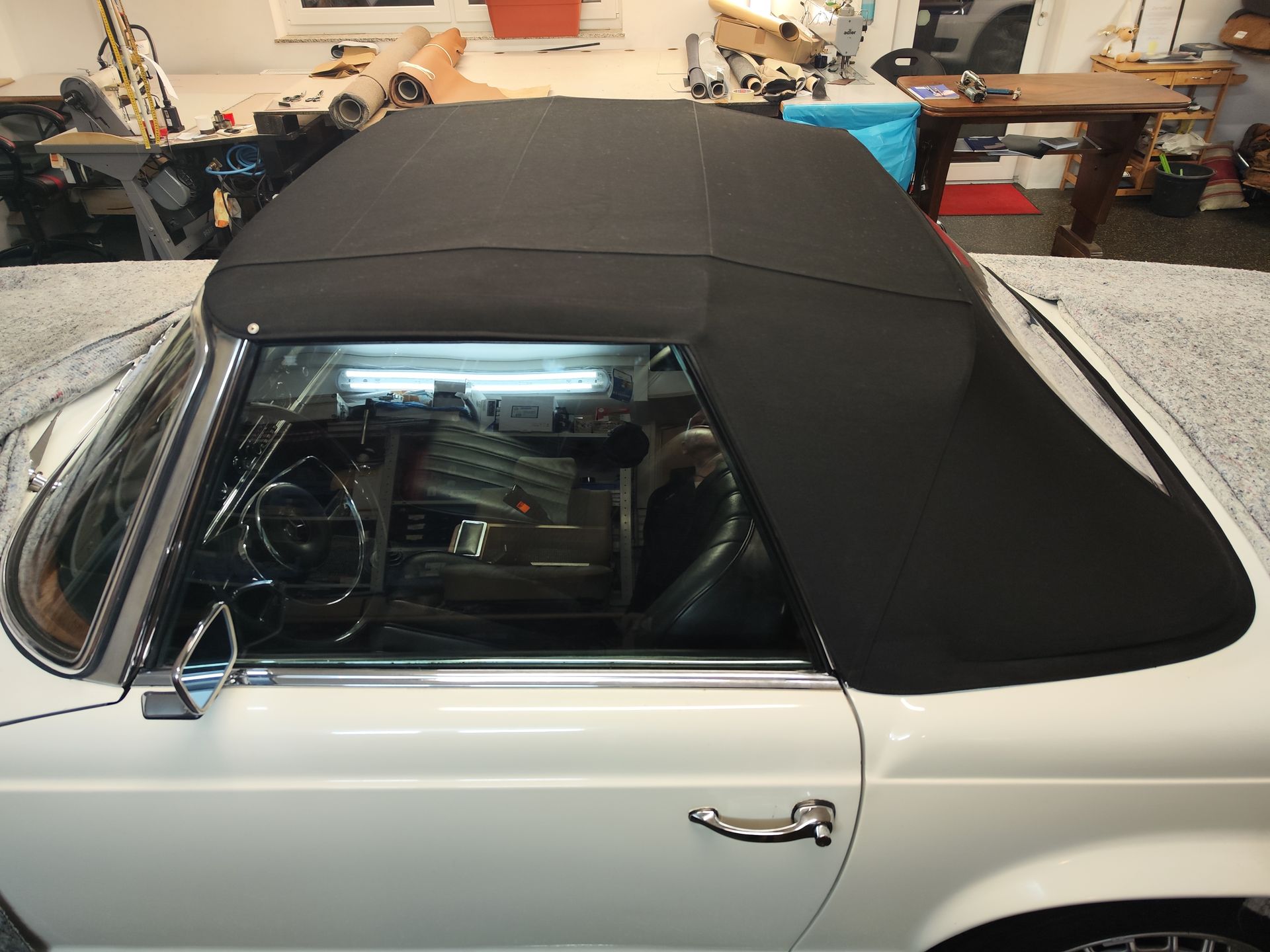 Ein weißes Auto mit einem schwarzen Cabrioverdeck