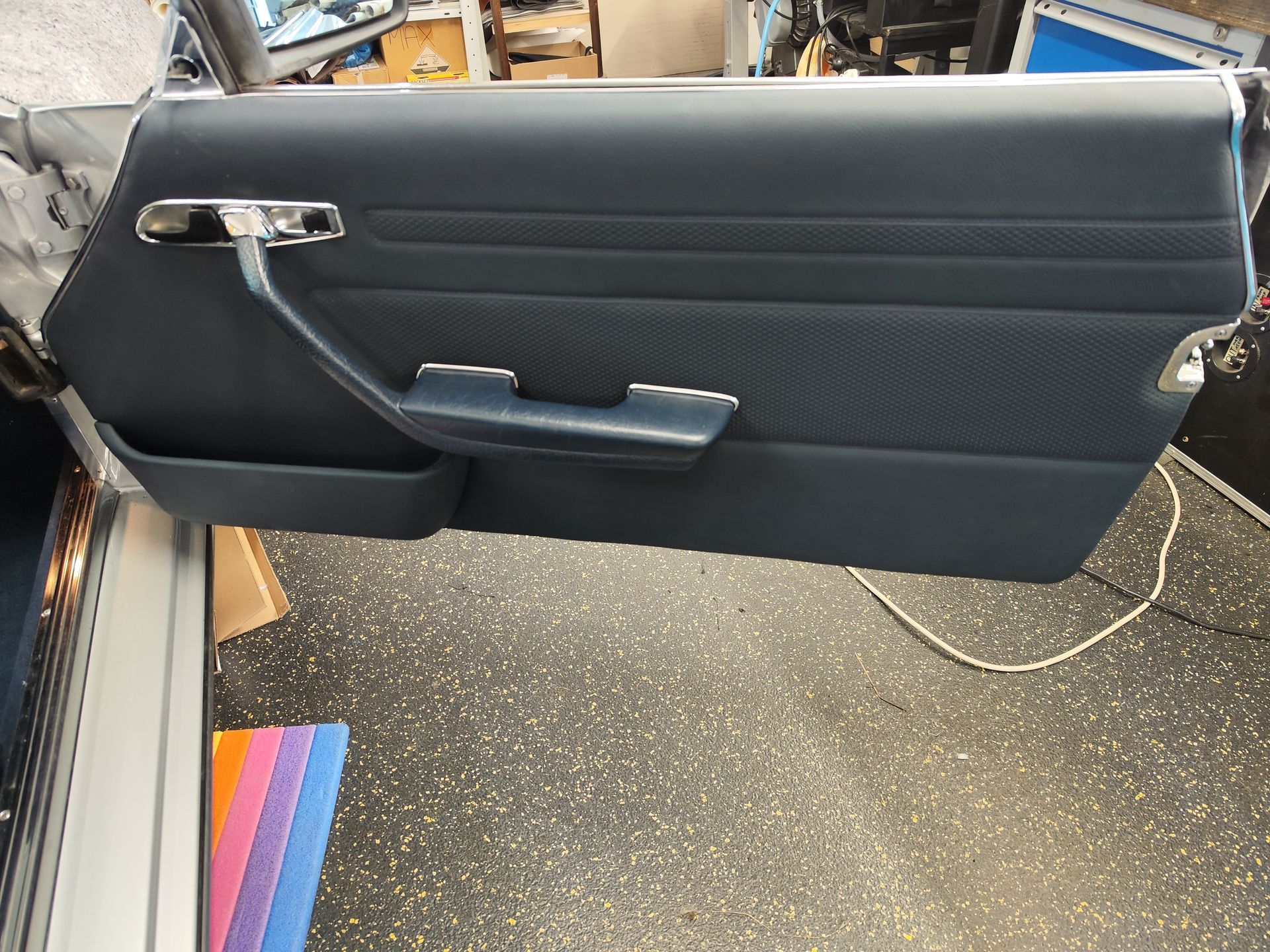 Eine blaue Autotür mit einem Chromgriff ist offen