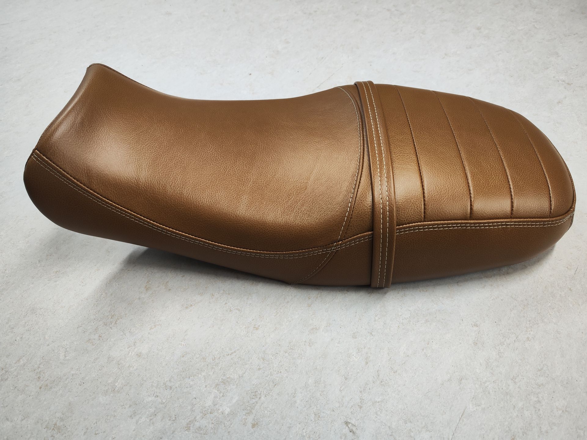 Ein brauner Ledersitz auf einer weißen Oberfläche