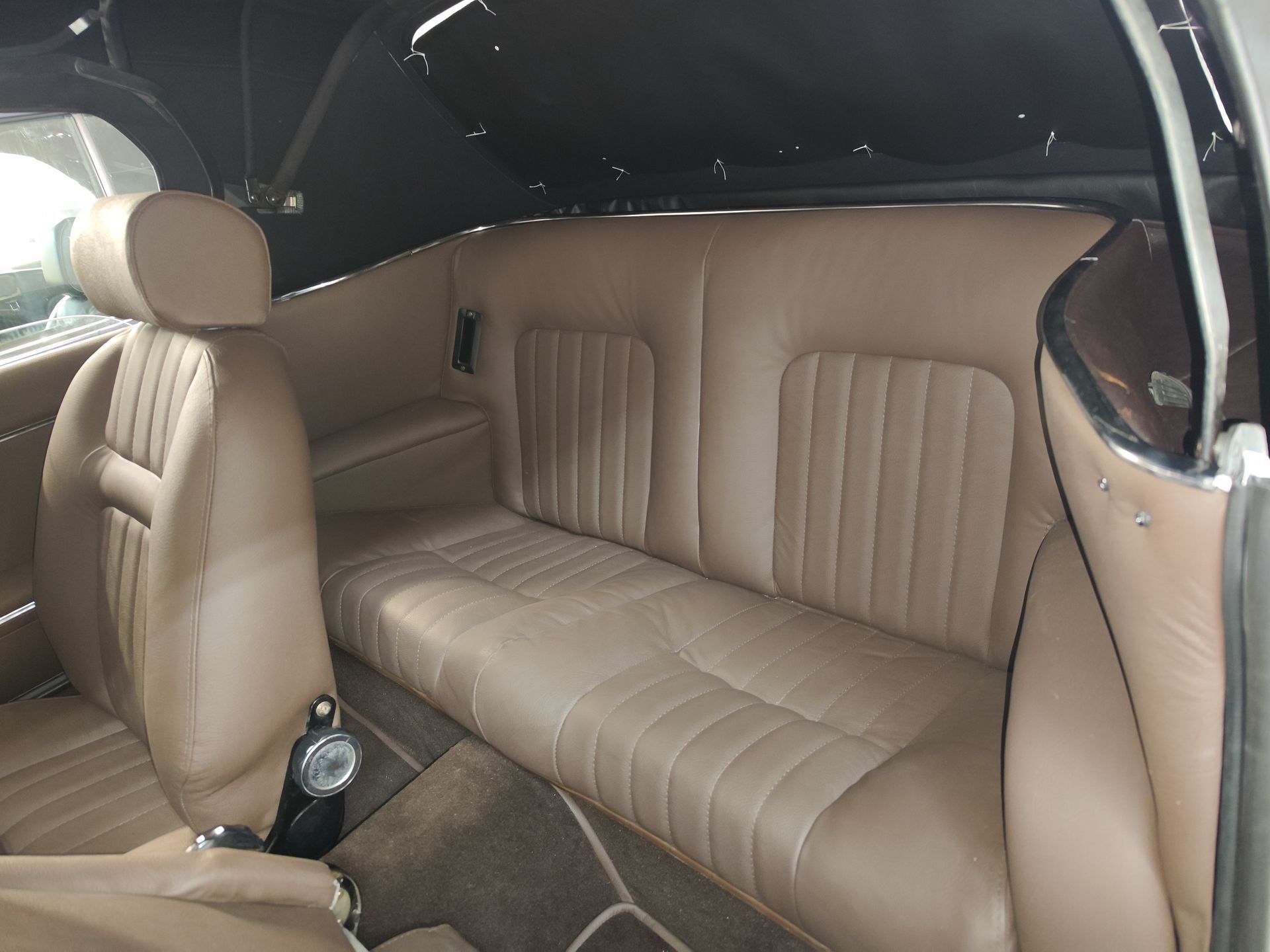 Der Rücksitz eines Autos mit hellbraunen Ledersitzen