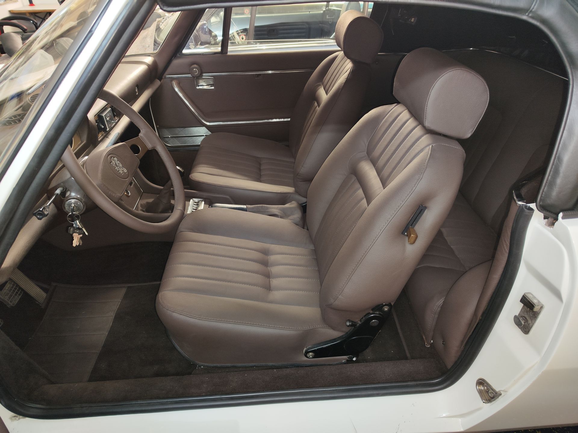 Ein weißes Auto mit braunen Sitzen und einem Lenkrad