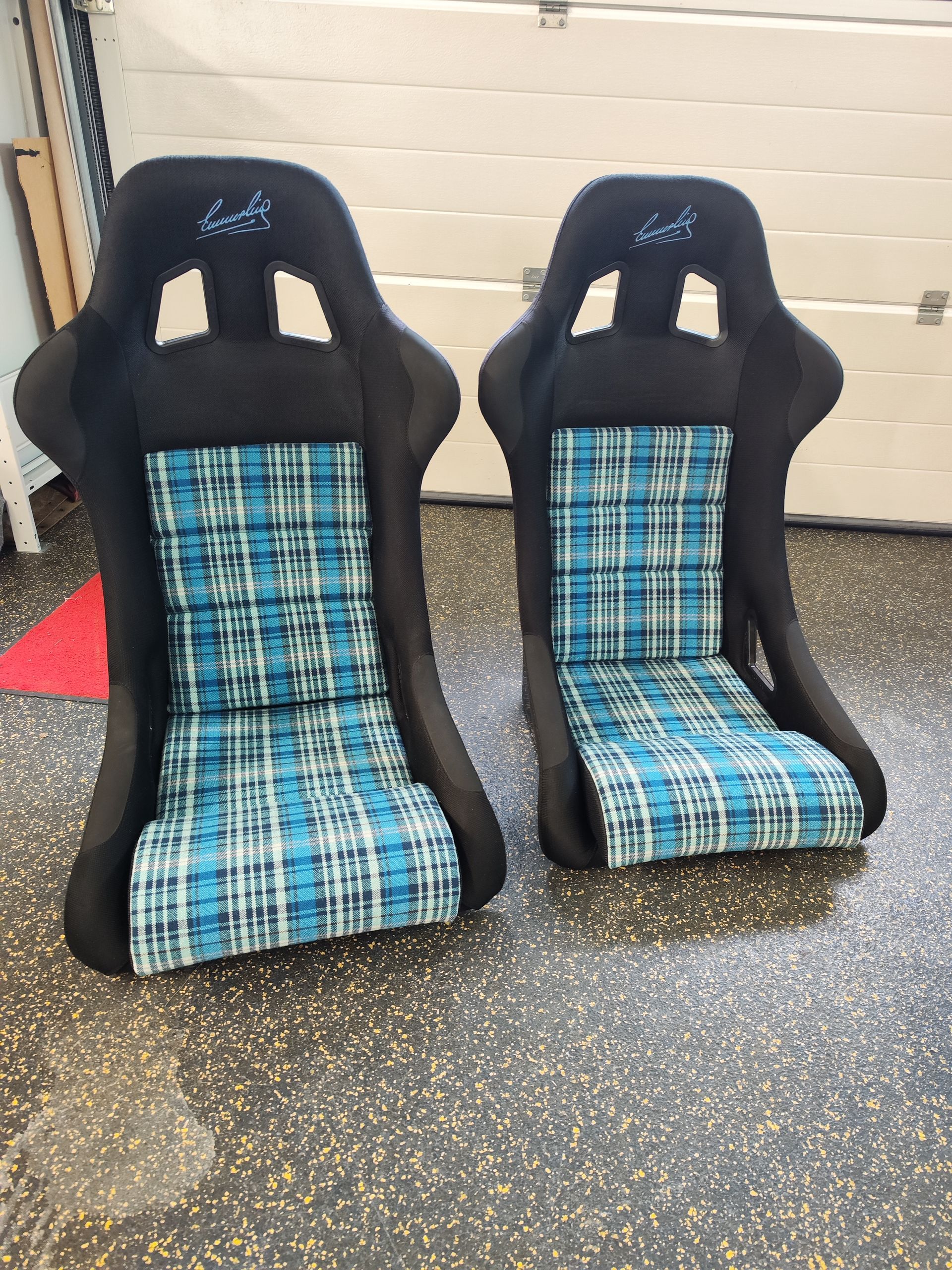 Zwei Rennsitze stehen auf einem Garagenboden