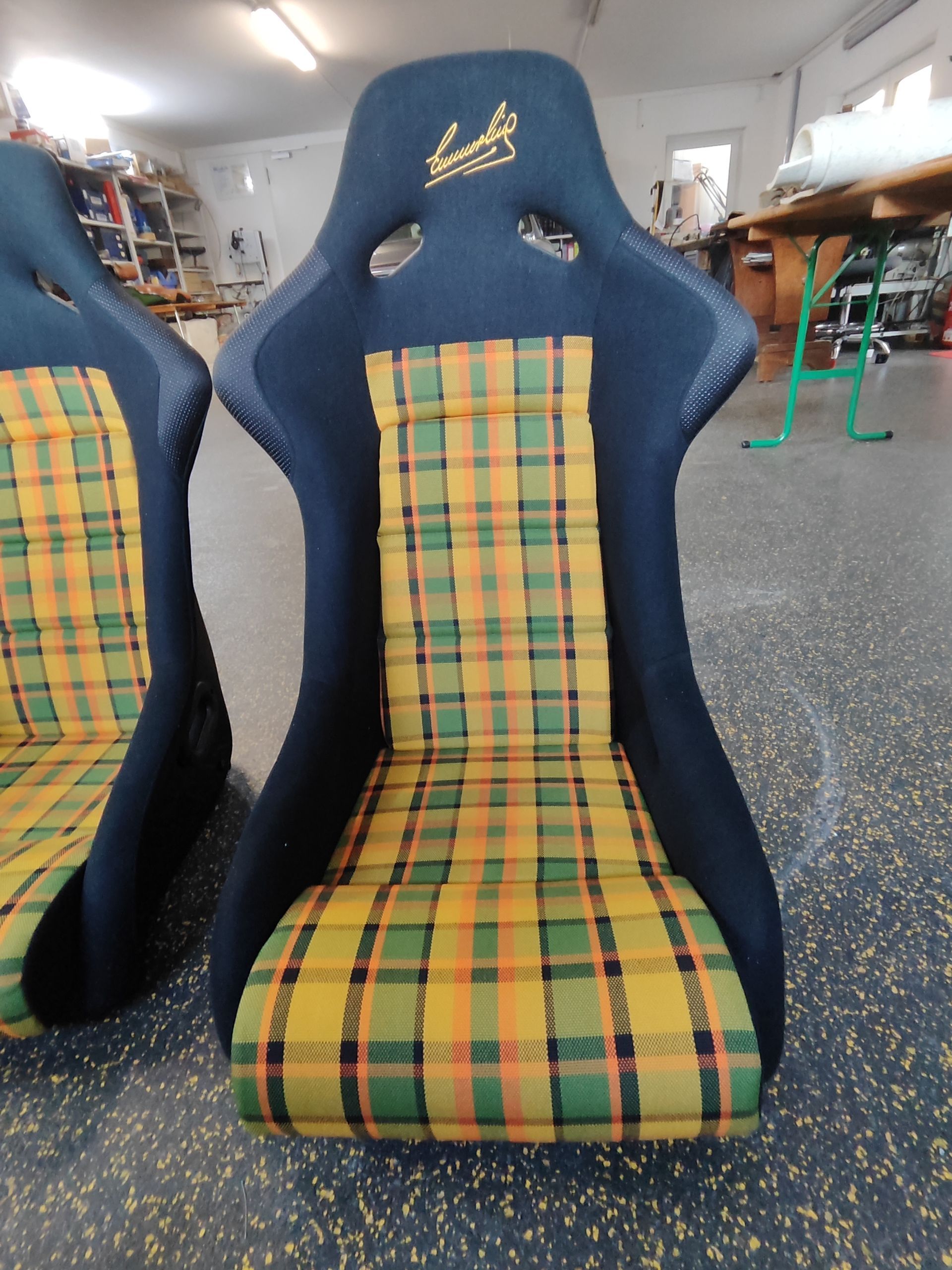 Ein Paar gelb und grün karierte Sitze in einer Garage