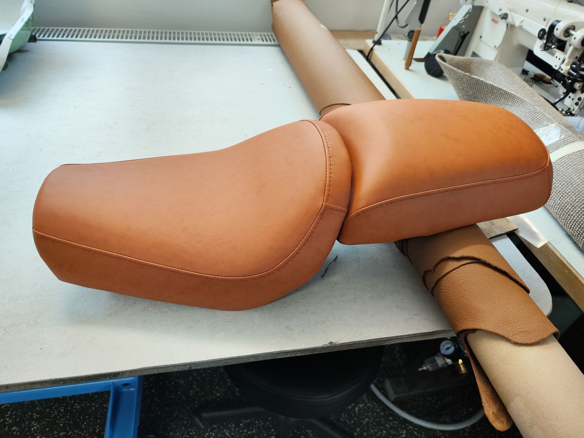 Ein brauner Motorradsitz aus Leder steht auf einem Tisch