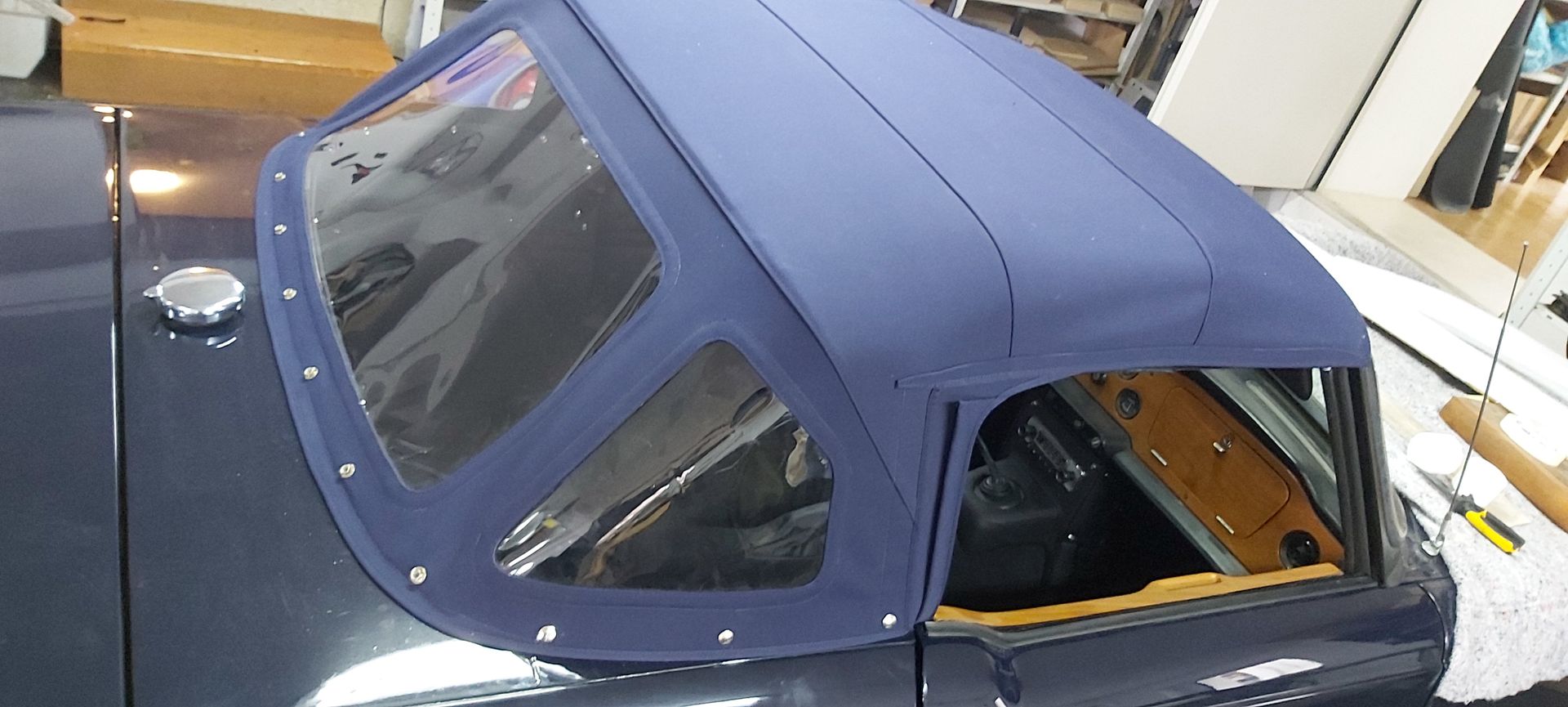 In einem Raum steht ein blaues Auto mit blauem Dach.