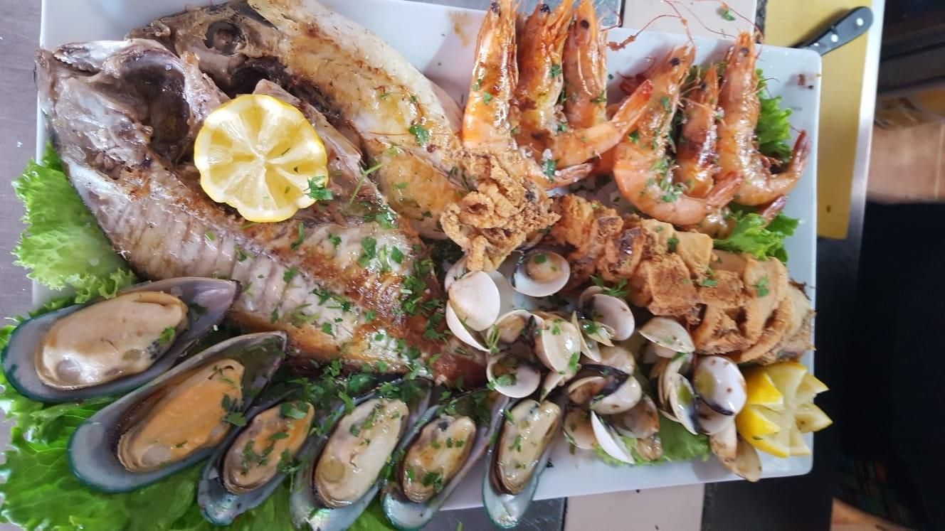 Plato de mariscos: pescado a la parrilla, camarones y calamares fritos, almejas, mejillones.