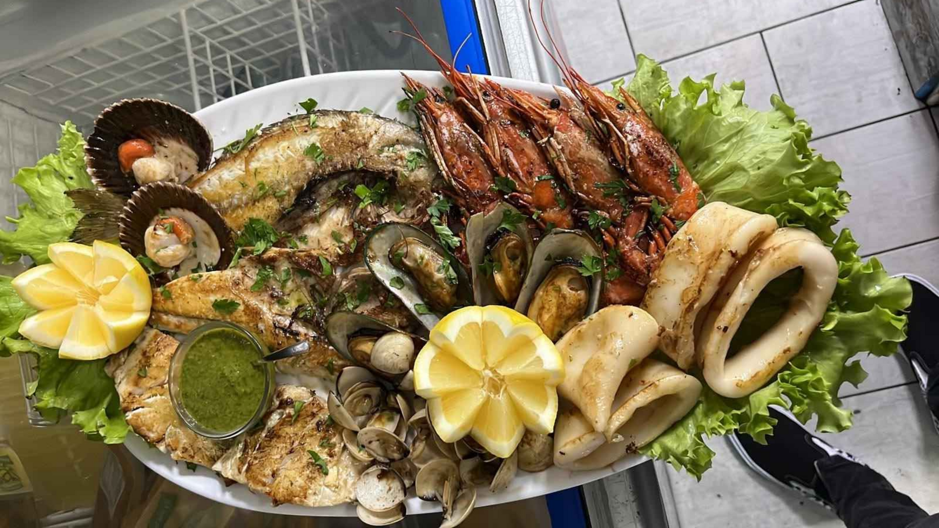 Plato de mariscos: pescado a la parrilla, camarones, mejillones, vieiras, calamares, guarnición.