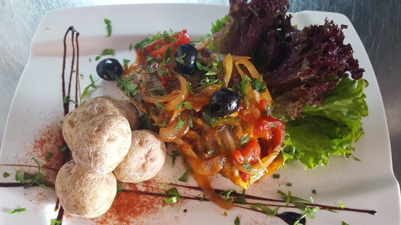 Plato de comida: patatas asadas, verduras y aceitunas, con glaseado balsámico y lechuga.