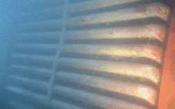 Vista de cerca de una parrilla industrial calentada, con colores que cambian de azul a naranja.