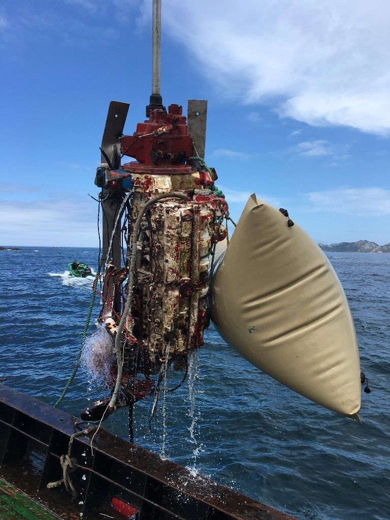 Un gran y complejo conjunto de sensores submarinos que se levanta del océano, con una boya inflable adjunta.