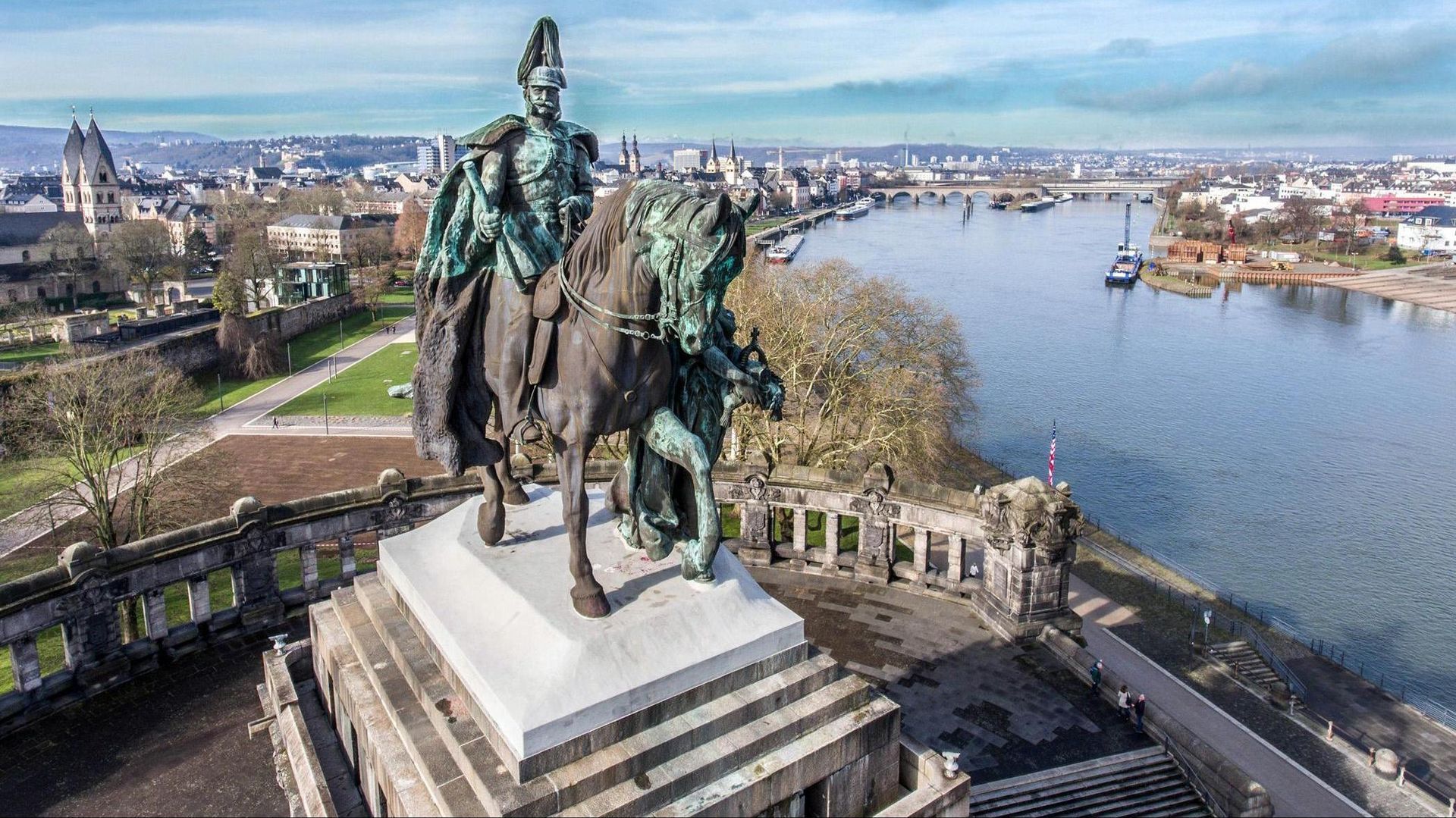 Reiterstatue mit Blick auf einen breiten Fluss und die Stadtlandschaft an einem sonnigen Tag