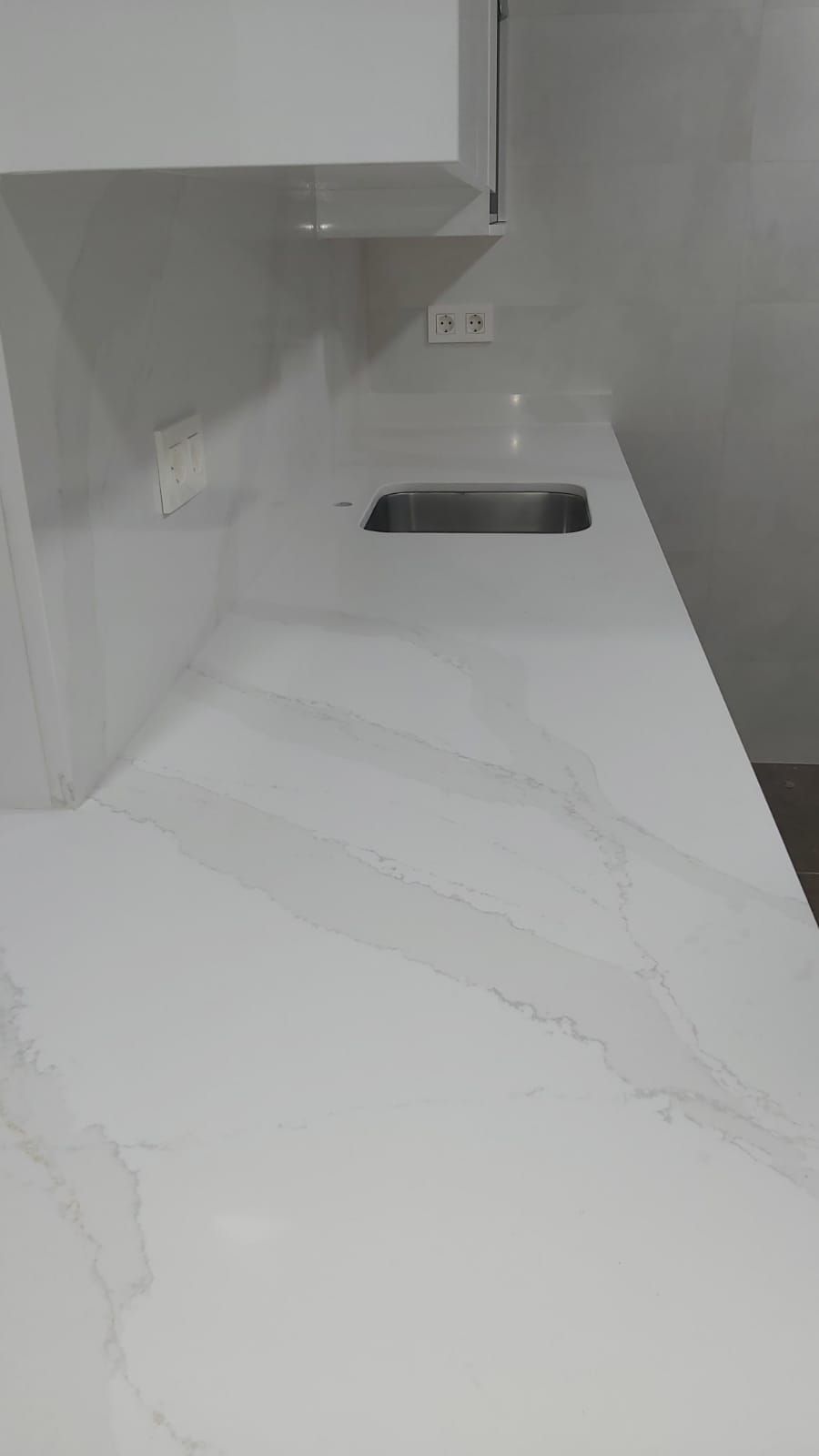 Una encimera blanca con fregadero en una cocina.