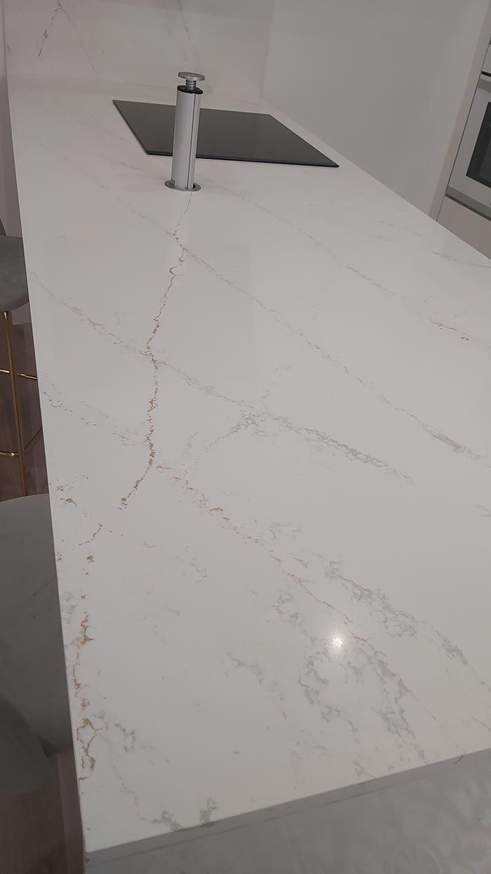 Una cocina con una gran encimera blanca y un horno de leña.