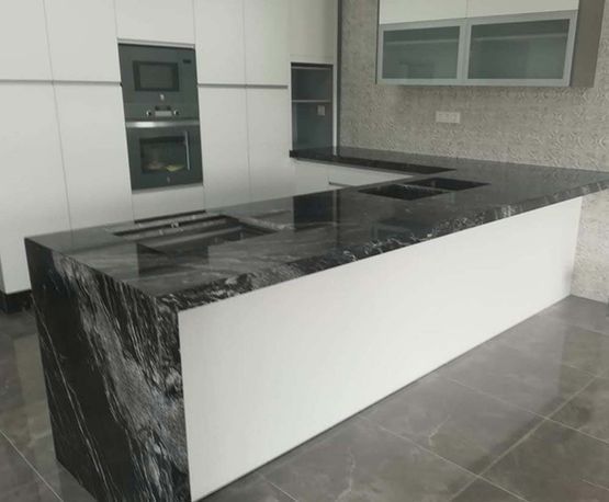 Hay una gran isla en el medio de la cocina.