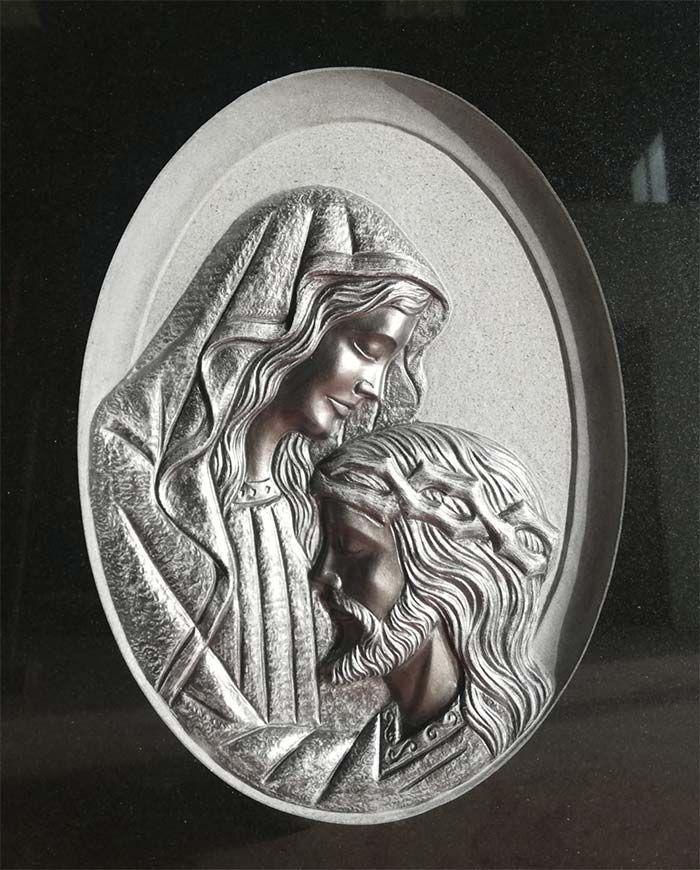 Una estatua de una mujer sosteniendo a Jesús con una corona de espinas.