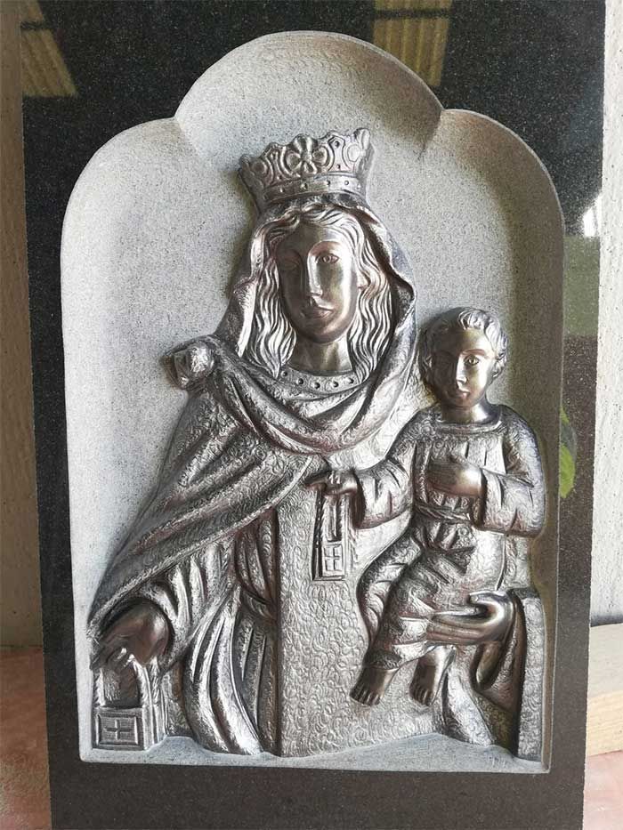 Una estatua de una mujer sosteniendo a un niño con una corona en la cabeza.