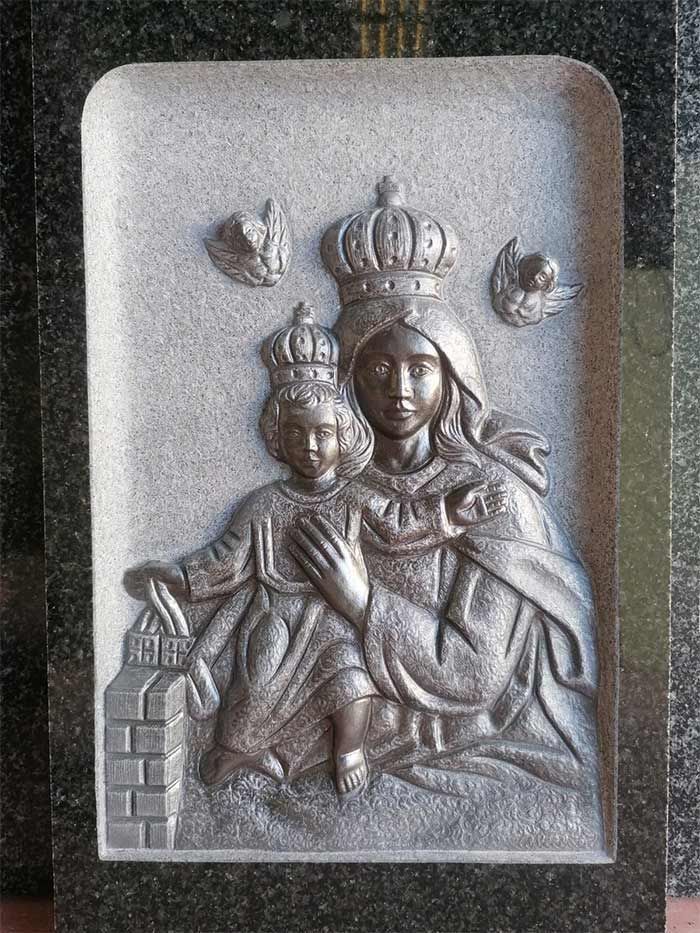 Una estatua de una mujer sosteniendo a un niño con una corona en la cabeza.