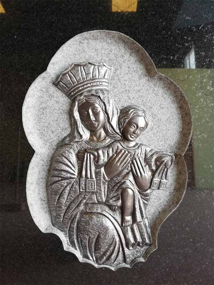 Una estatua de una mujer sosteniendo a un niño con una corona en la cabeza.