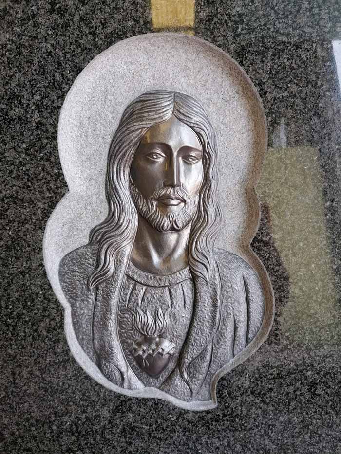 Una estatua de Jesús está tallada en una losa de granito.