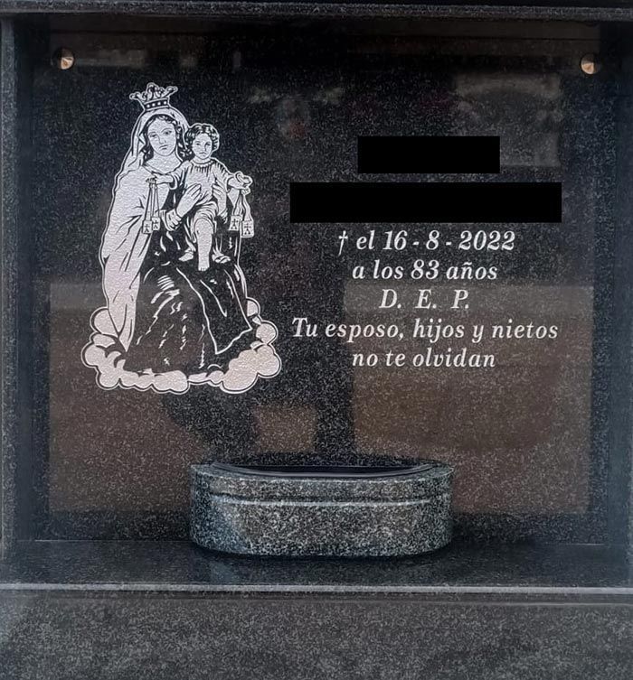 Una lápida con la imagen de una mujer sosteniendo a un niño.