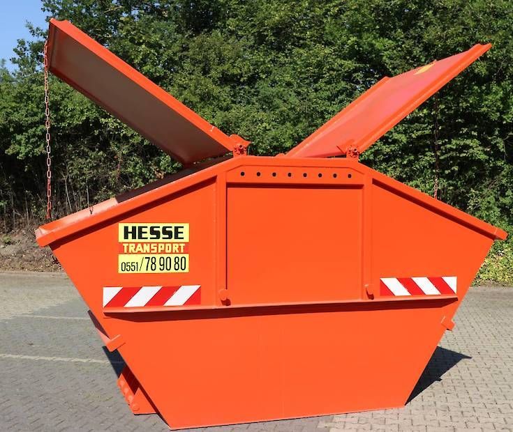 Ein leuchtend orangefarbener Metallcontainer mit offenen Deckeln steht auf einem gepflasterten Parkplatz.